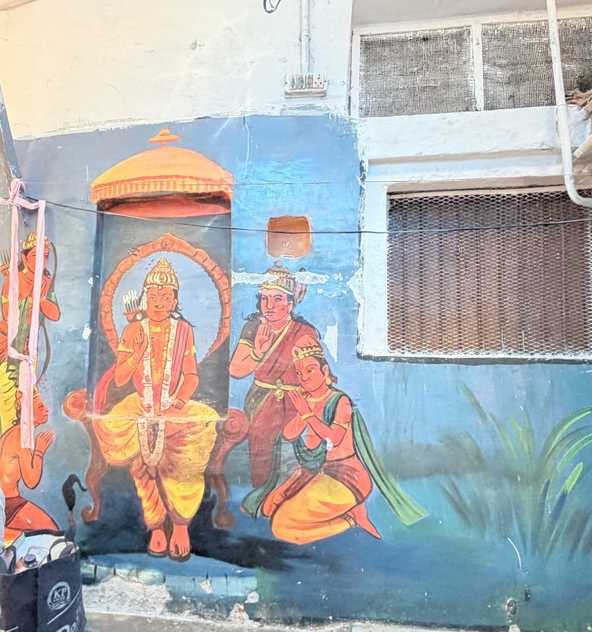 A mural of Ram enthroned, with Sita, Lakshman and Hanuman, painted on a blue wall in a Kashi lane