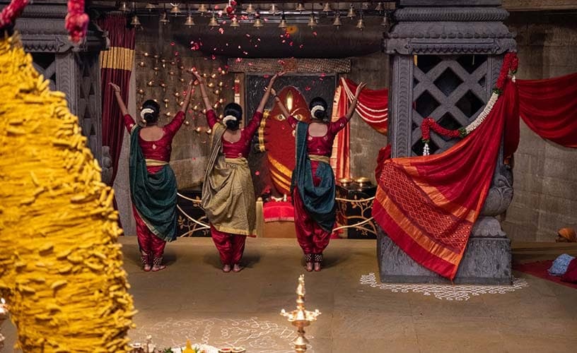 Dancers with arms raised in offering before Linga Bhairavi
