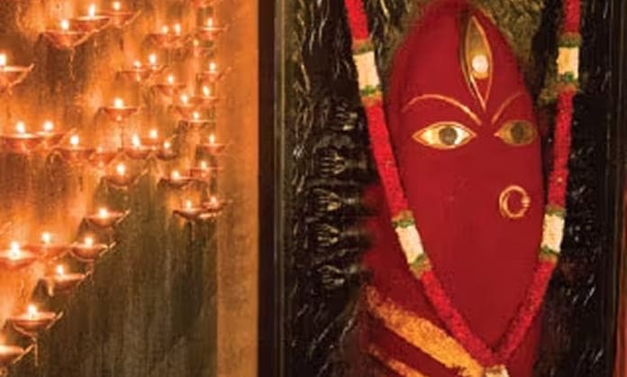 Linga Bhairavi adorned in red for Navratri, among rows of lit lamps
