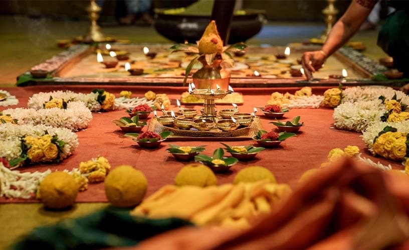 Lamps, flowers and laddoos arranged on a kolam for Navratri
