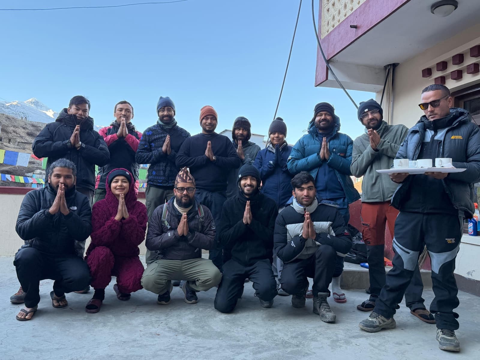 A group of seekers in prayer pose at a mountain lodge terrace along the Annapurna Circuit