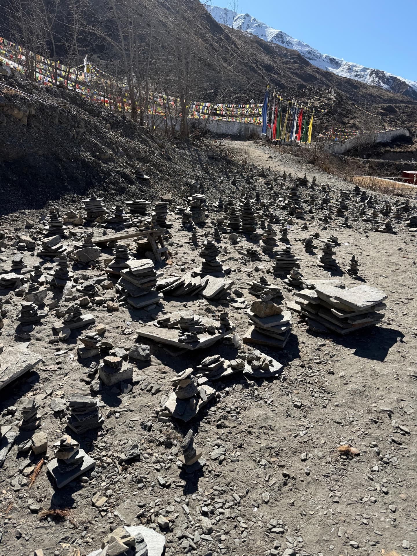 Sacred Nepal yatra — stone cairns and prayer flags with Himalayan peaks